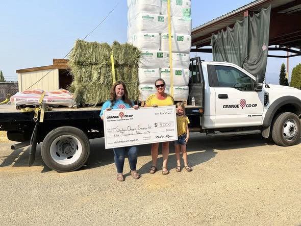 Grange Co-op delivering a truckload of hay and a donation check to SOEA
