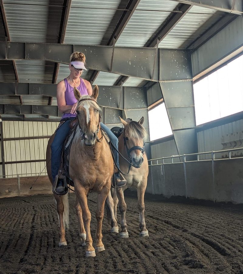 Kris Oyler riding in an indoor arena